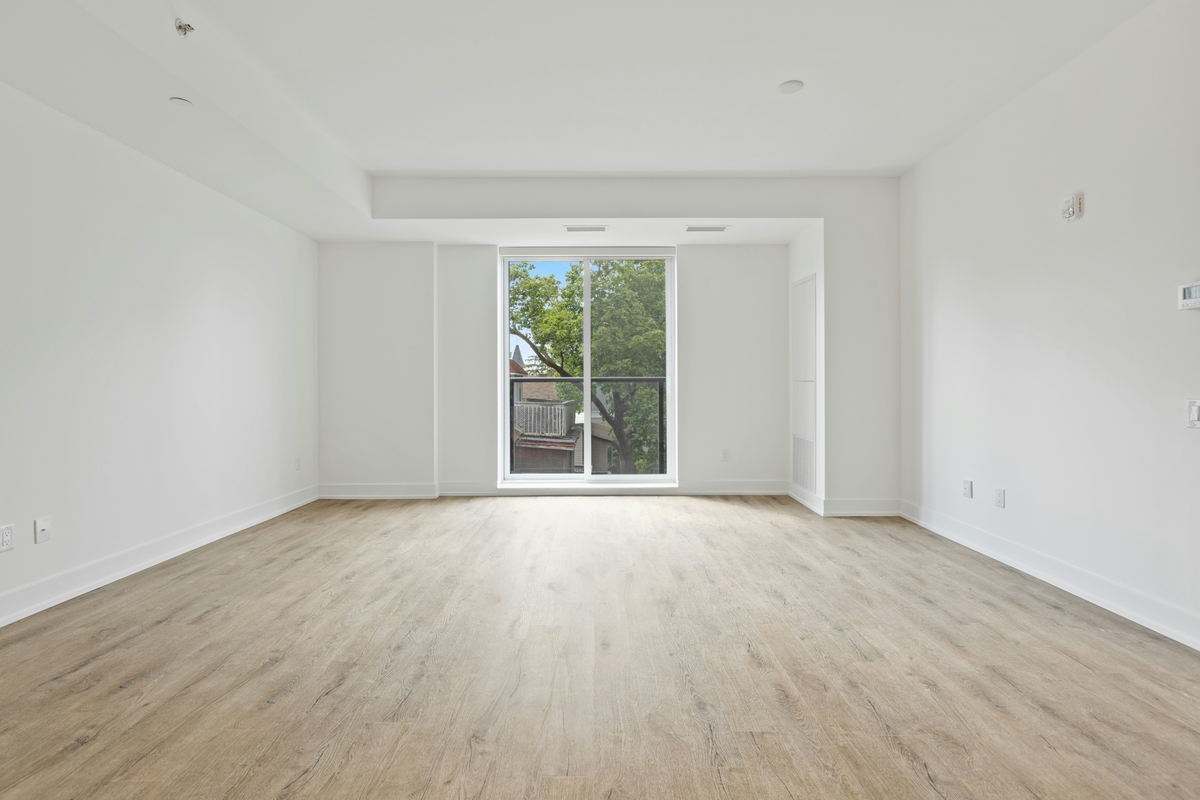 Empty white room with wooden floor and large window