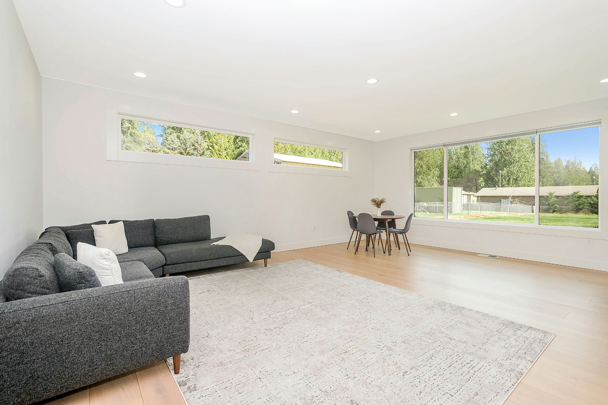 Spacious living room with large windows and tree views